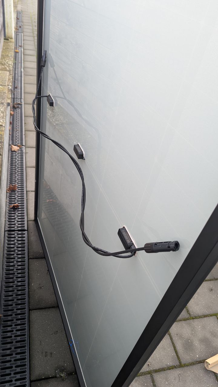 Verdrillte Solarkabel hinter einem Solarmodul